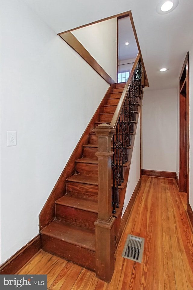 staircase with hardwood / wood-style floors