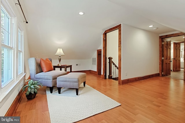 sitting room with a healthy amount of sunlight, vaulted ceiling, and light hardwood / wood-style floors