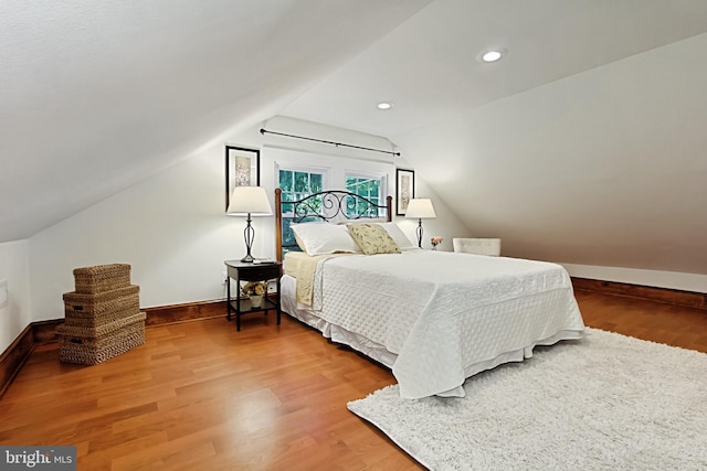 bedroom featuring hardwood / wood-style flooring and vaulted ceiling