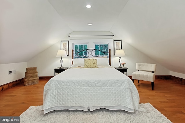 bedroom featuring hardwood / wood-style flooring and vaulted ceiling