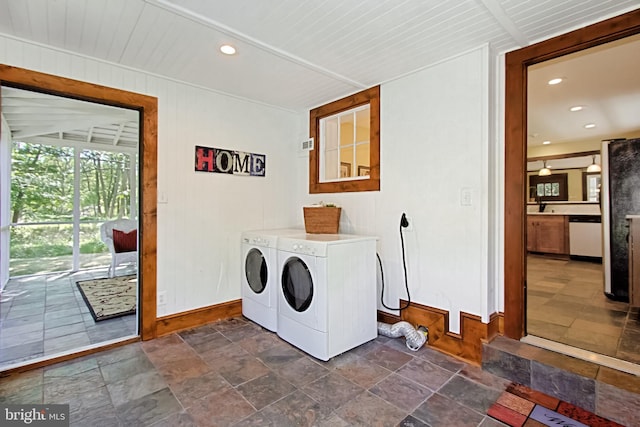 washroom featuring wooden walls, washing machine and dryer, and wooden ceiling