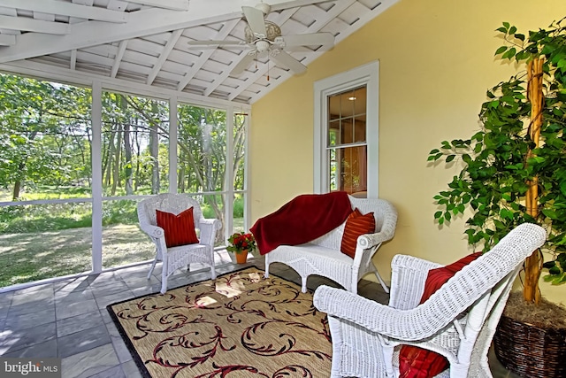 sunroom / solarium with lofted ceiling with beams, wood ceiling, a healthy amount of sunlight, and ceiling fan