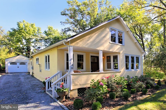 view of front of house featuring an outbuilding, a garage, and covered porch