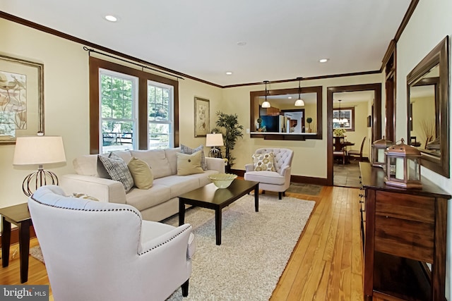 living room with a notable chandelier, crown molding, and hardwood / wood-style flooring