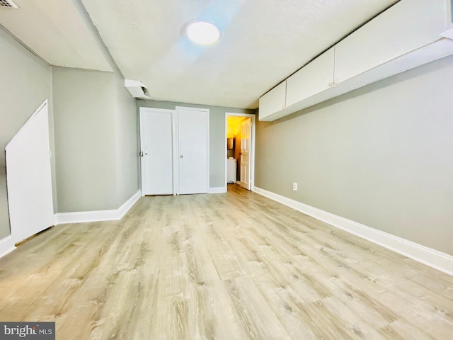 basement with light hardwood / wood-style flooring