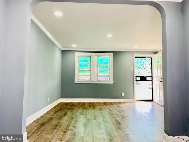 empty room featuring hardwood / wood-style flooring and ornamental molding