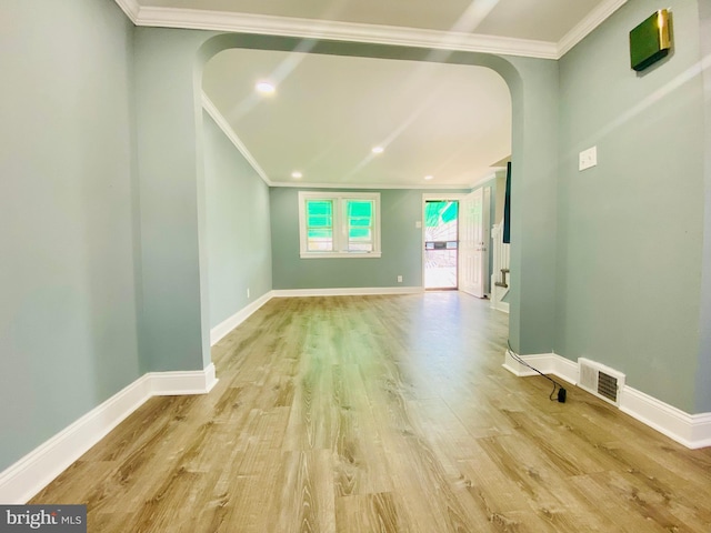 unfurnished living room featuring light hardwood / wood-style floors and crown molding