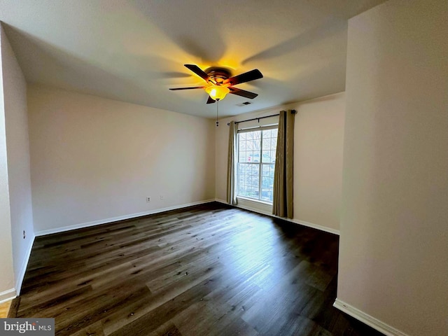 unfurnished room with ceiling fan and dark wood-type flooring