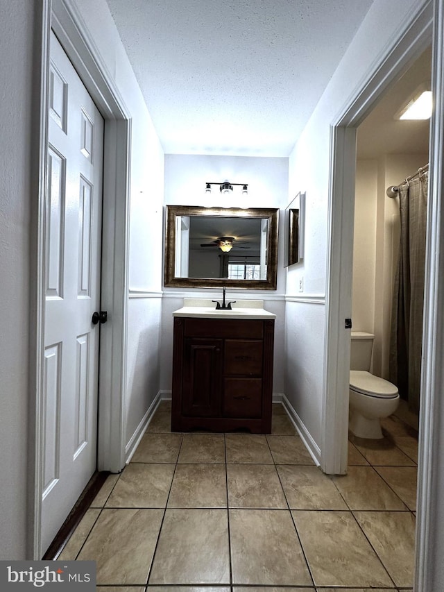 bathroom featuring walk in shower, tile patterned flooring, vanity, and toilet