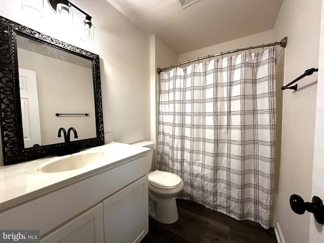 bathroom with toilet, vanity, and hardwood / wood-style flooring