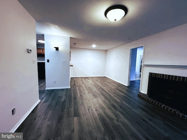 unfurnished living room featuring a textured ceiling and dark hardwood / wood-style floors