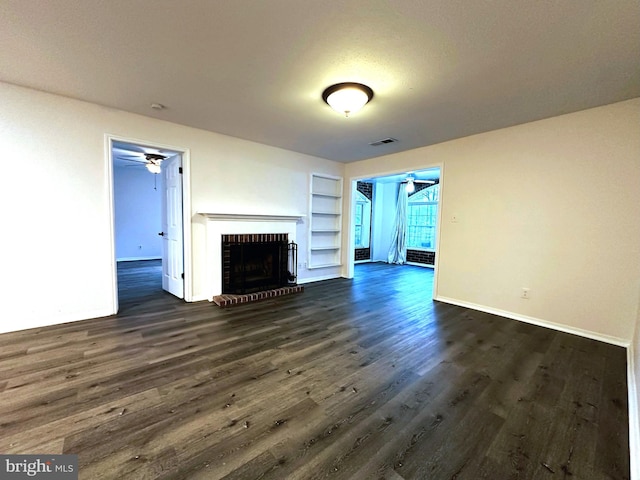 unfurnished living room with ceiling fan, a fireplace, dark wood-type flooring, and built in features