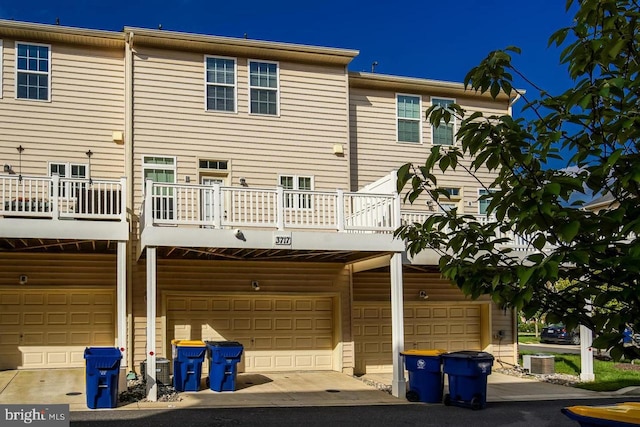 rear view of property featuring cooling unit and a garage