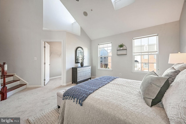 bedroom with a spacious closet, light carpet, high vaulted ceiling, and a closet