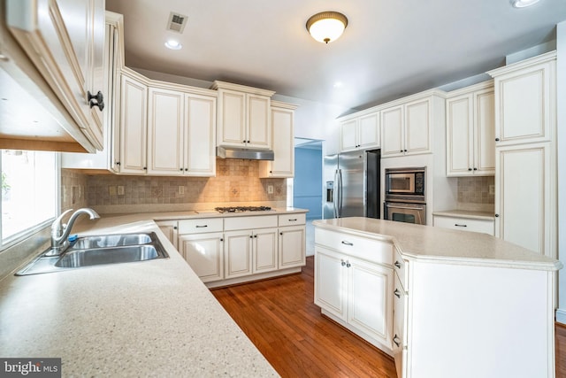 kitchen featuring hardwood / wood-style flooring, sink, stainless steel appliances, and tasteful backsplash