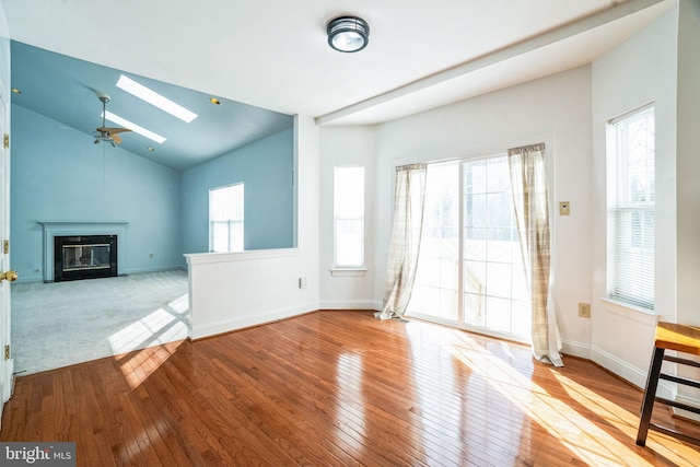 unfurnished living room featuring ceiling fan, a healthy amount of sunlight, and light hardwood / wood-style flooring