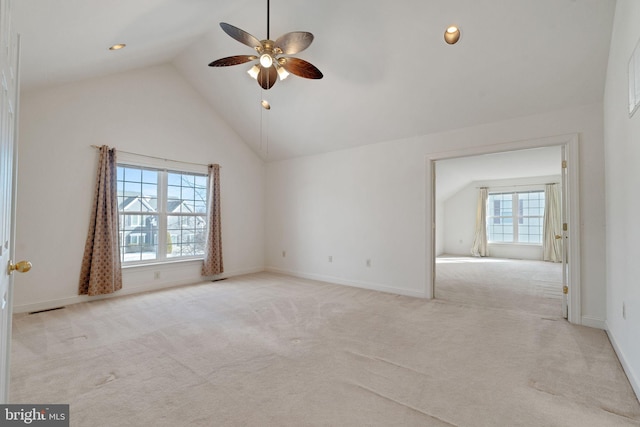 carpeted empty room featuring ceiling fan, a wealth of natural light, and high vaulted ceiling