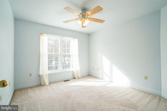 spare room with ceiling fan and light colored carpet