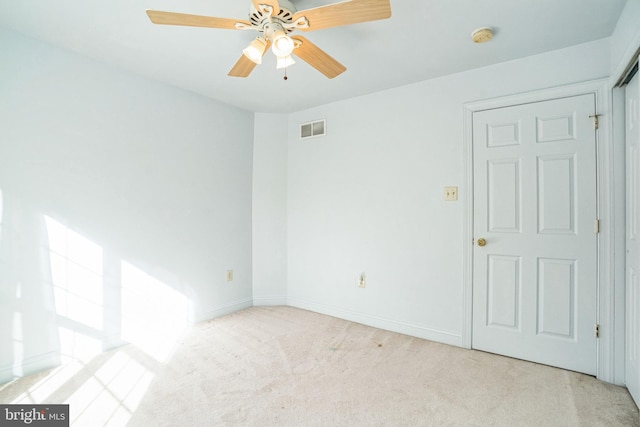 carpeted spare room featuring ceiling fan