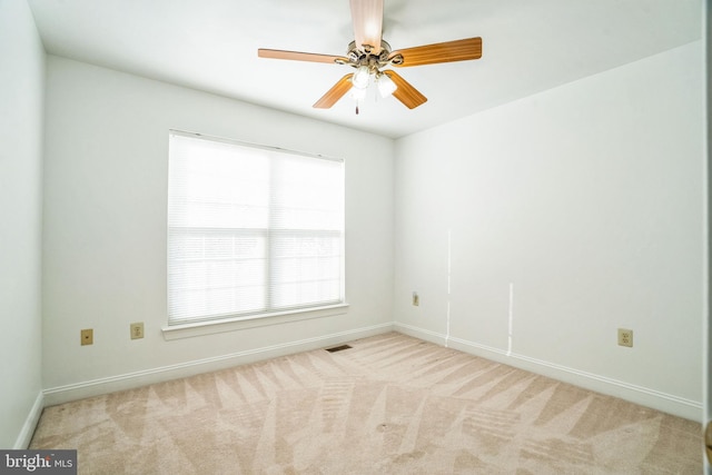 spare room featuring light carpet and ceiling fan