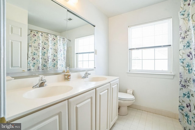 bathroom featuring toilet, vanity, and curtained shower