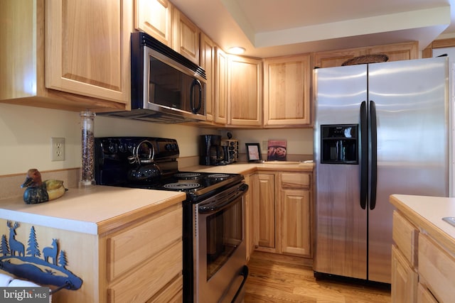 kitchen featuring appliances with stainless steel finishes, light brown cabinets, and light hardwood / wood-style floors