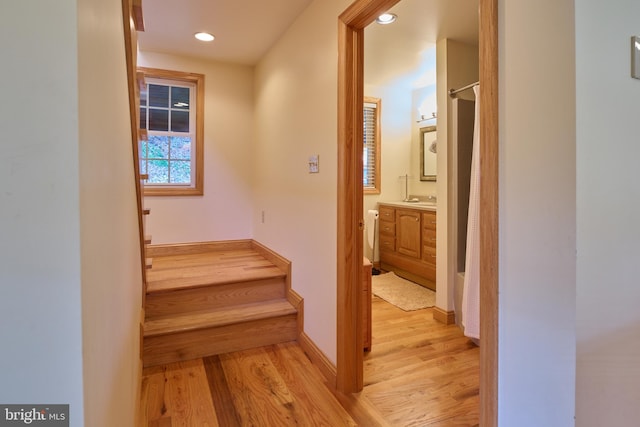 stairway with sink and hardwood / wood-style floors