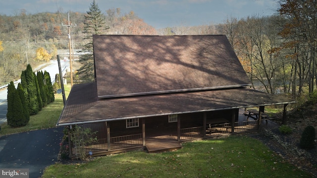 view of side of home featuring a deck and a lawn