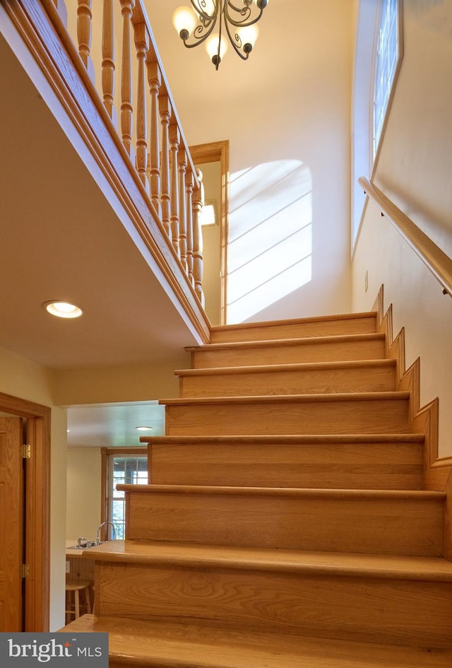 stairway featuring a chandelier