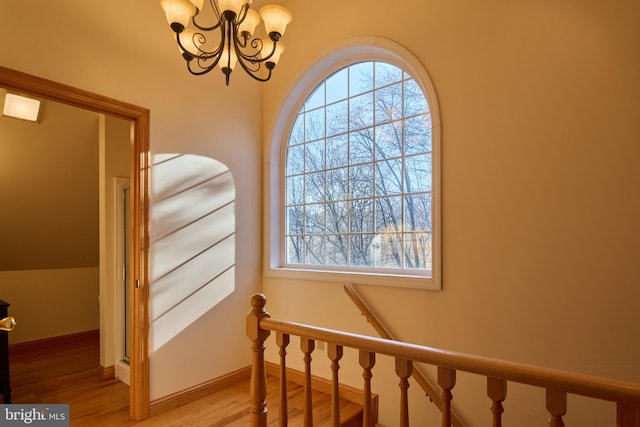 staircase featuring a chandelier and hardwood / wood-style floors