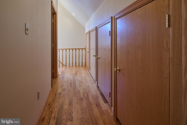 corridor featuring lofted ceiling and light wood-type flooring