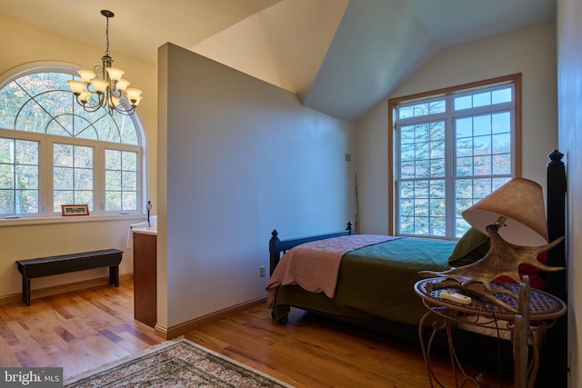 bedroom featuring multiple windows, lofted ceiling, and light wood-type flooring