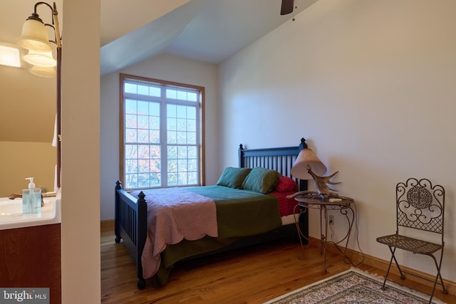 bedroom with vaulted ceiling, wood-type flooring, and ceiling fan