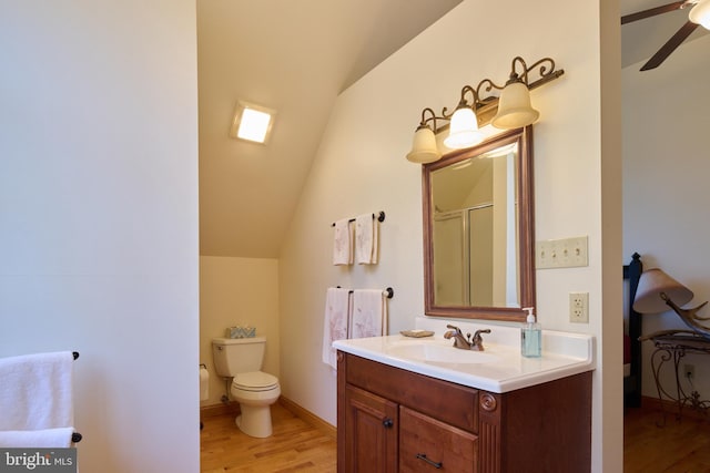 bathroom featuring hardwood / wood-style floors, toilet, walk in shower, vaulted ceiling, and vanity