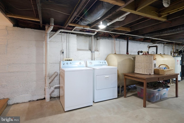 washroom with washing machine and dryer and water heater