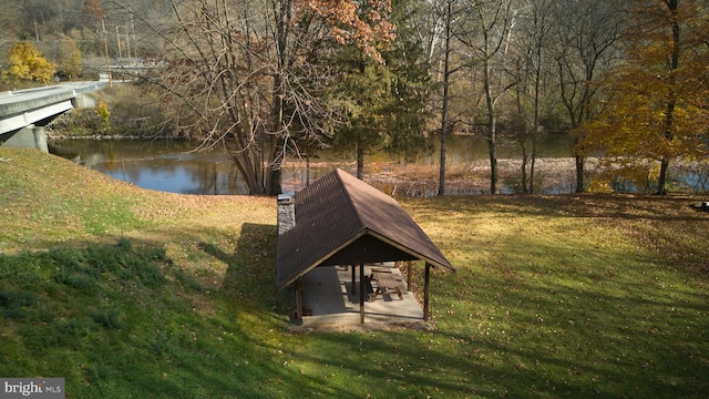 view of property's community with a water view and a yard