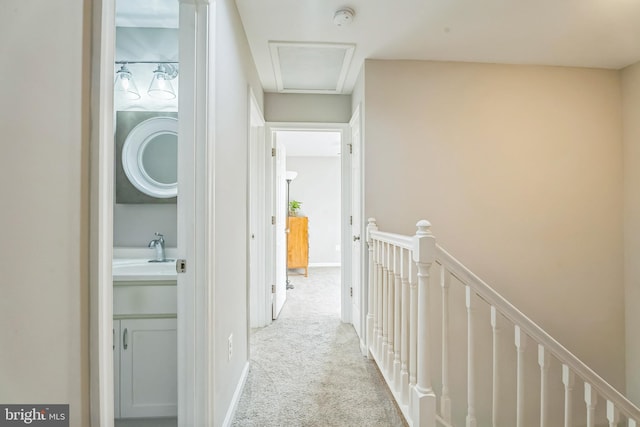 hallway with sink and light carpet