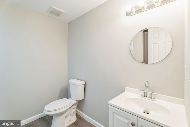 bathroom with vanity, hardwood / wood-style flooring, and toilet