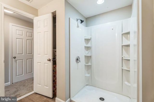 bathroom with hardwood / wood-style floors and a shower