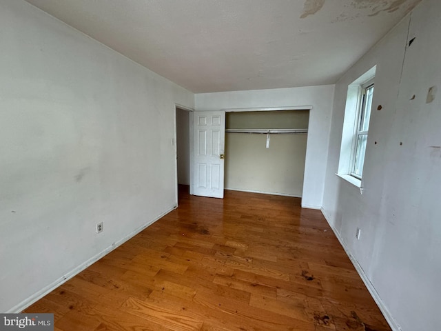 unfurnished bedroom featuring a closet and hardwood / wood-style flooring