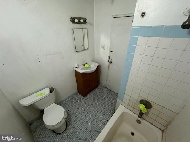 full bathroom featuring tiled shower / bath, vanity, toilet, and tile patterned floors