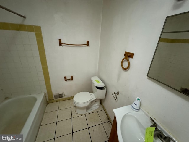 bathroom featuring toilet, tiled shower / bath combo, and tile patterned floors