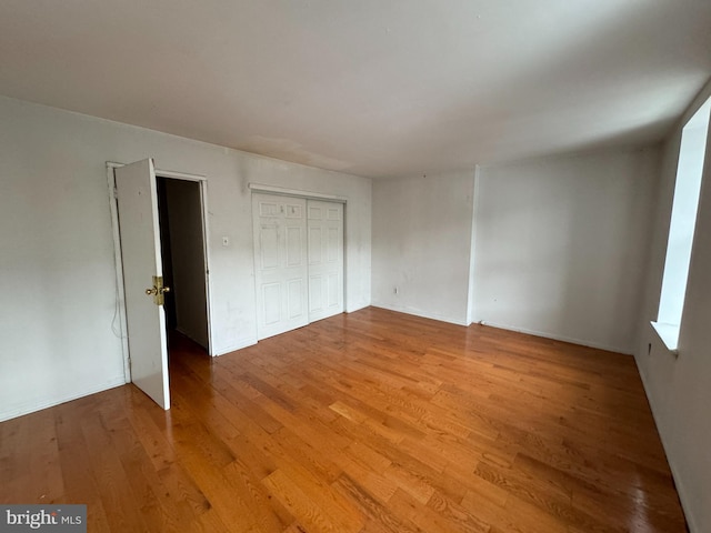 unfurnished bedroom with hardwood / wood-style flooring and a closet