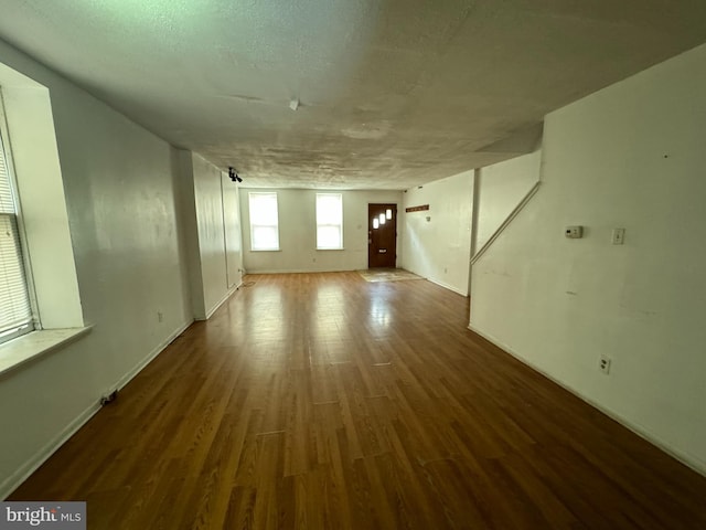 empty room with a textured ceiling and dark hardwood / wood-style floors