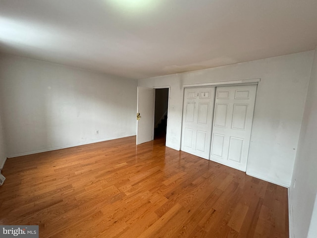 unfurnished bedroom featuring light hardwood / wood-style flooring and a closet