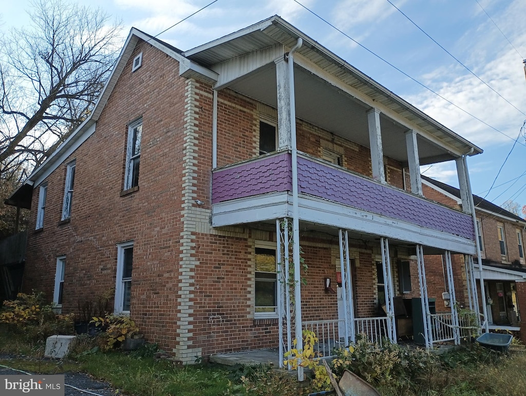 view of property exterior with a porch and a balcony