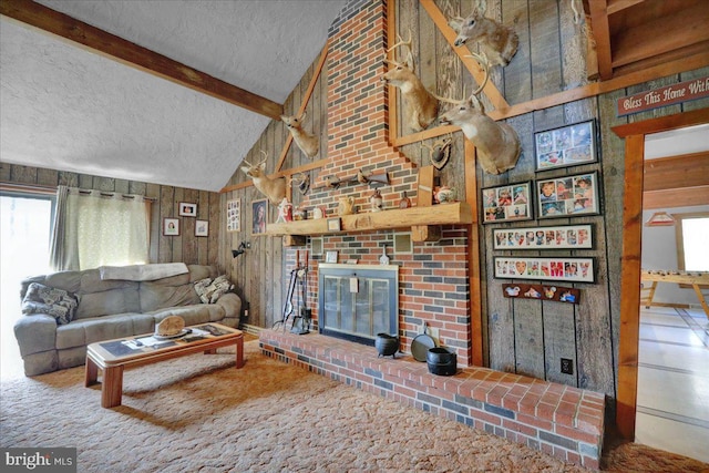 living room featuring wood walls, a fireplace, a textured ceiling, beamed ceiling, and high vaulted ceiling