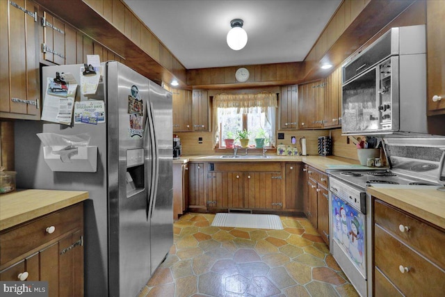 kitchen featuring sink, stainless steel refrigerator with ice dispenser, and electric stove