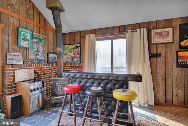 bar featuring wood walls, a textured ceiling, and lofted ceiling