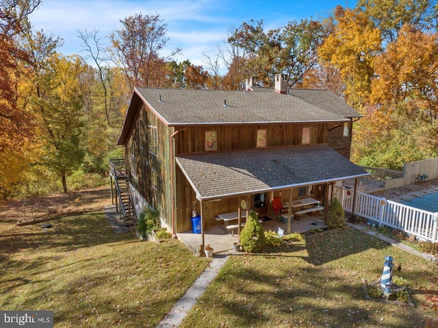 back of house featuring a patio area and a lawn